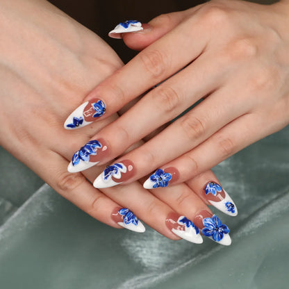 Glossy almond press-on nails with blue flowers and rhinestones